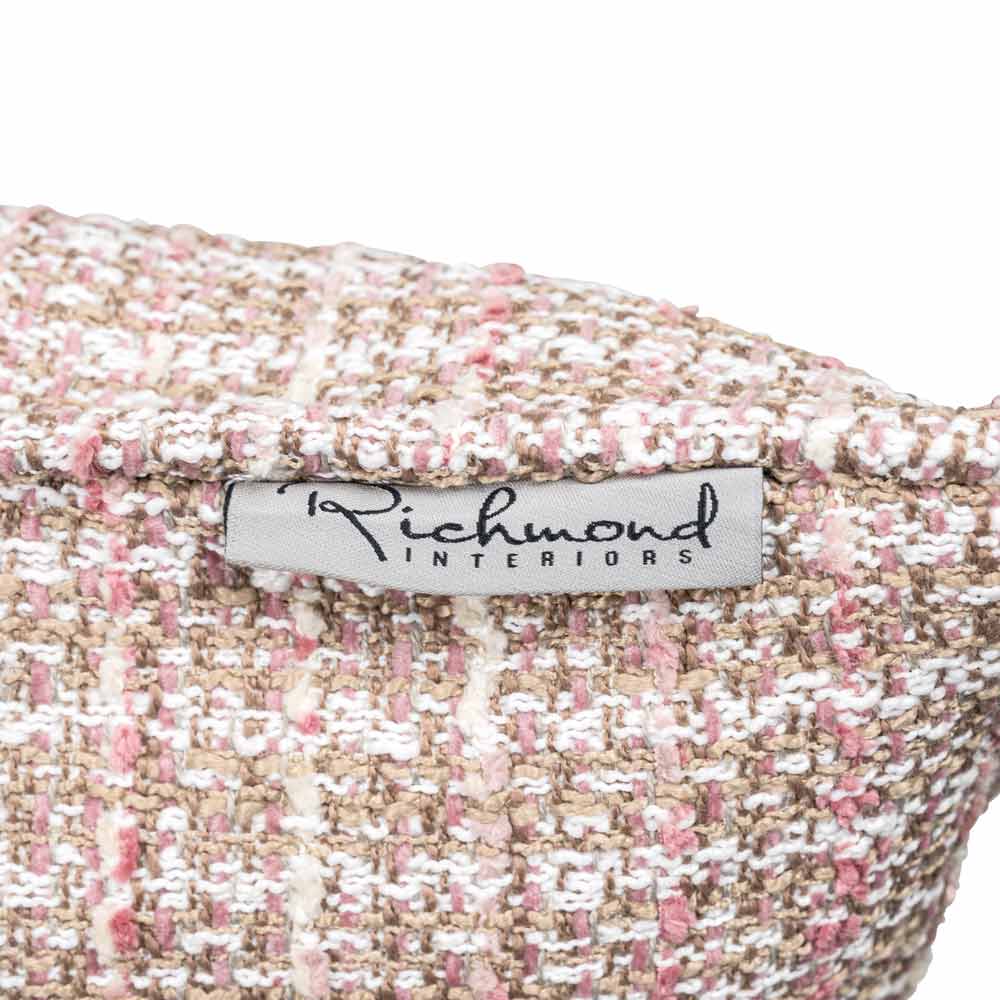 Detailaufnahme eines strukturierten Stoffes in Rosa und Weiß mit dem Label ‘Richmond Interiors’ in eleganter, schwarzer Schrift.